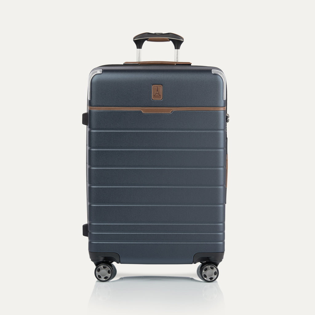 Front view of  Medium Check-In Spinner in Monaco Blue, featuring brown trim, hard shell exterior, and dual spinner wheels.
