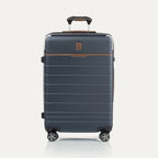 Front view of  Medium Check-In Spinner in Monaco Blue, featuring brown trim, hard shell exterior, and dual spinner wheels.
