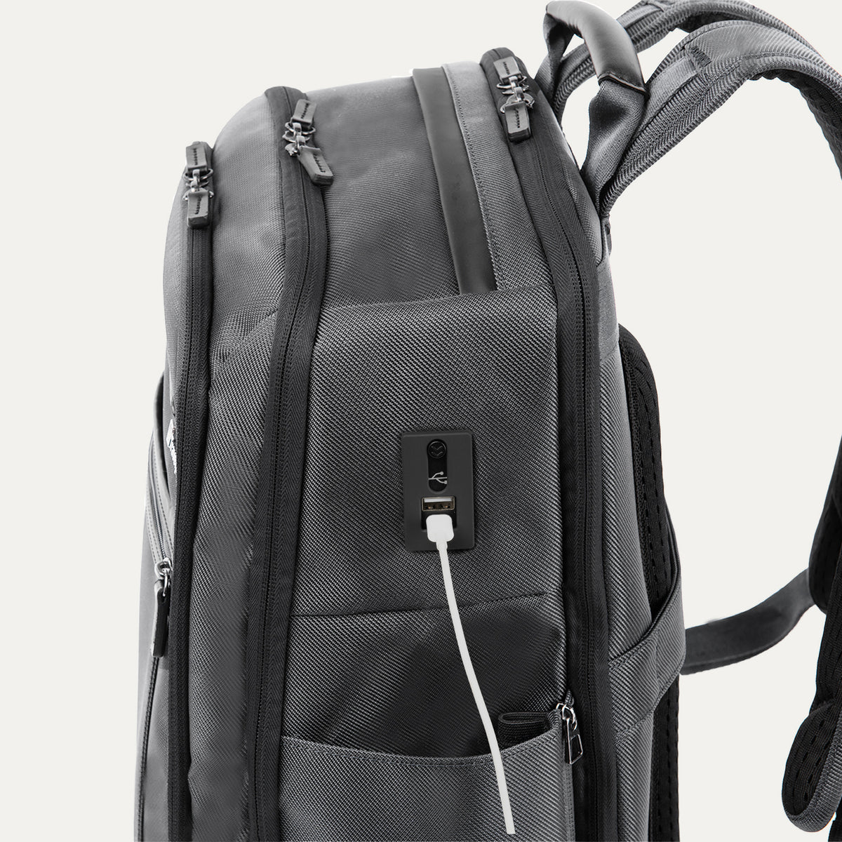 Side detail view of the Travelpro Crew Executive Choice 3 Large Travel Backpack in Titanium Grey, highlighting the integrated USB A and C charging ports for convenient power connectivity on the go.