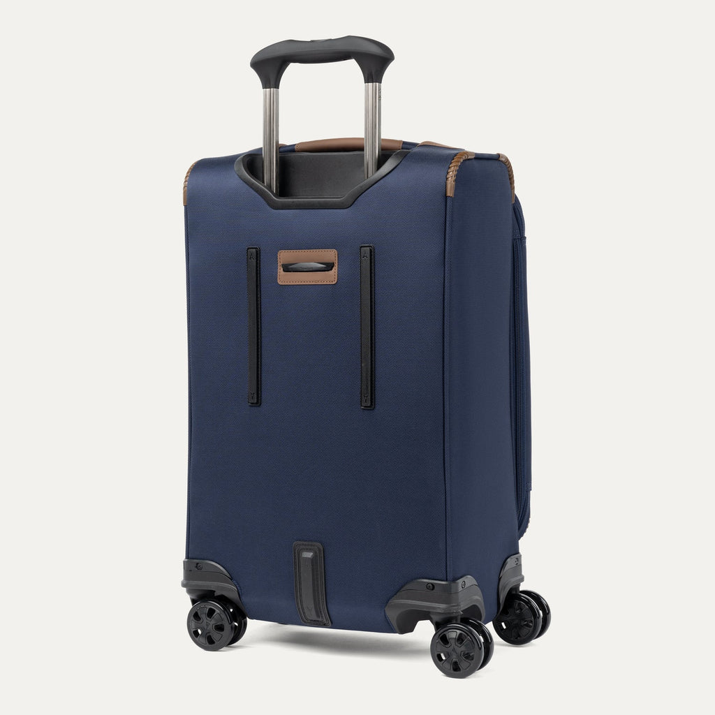 Rear view of a Travelpro Crew Classic Spinner in Patriot Blue, showing dual spinner wheels and protective corner guards.
