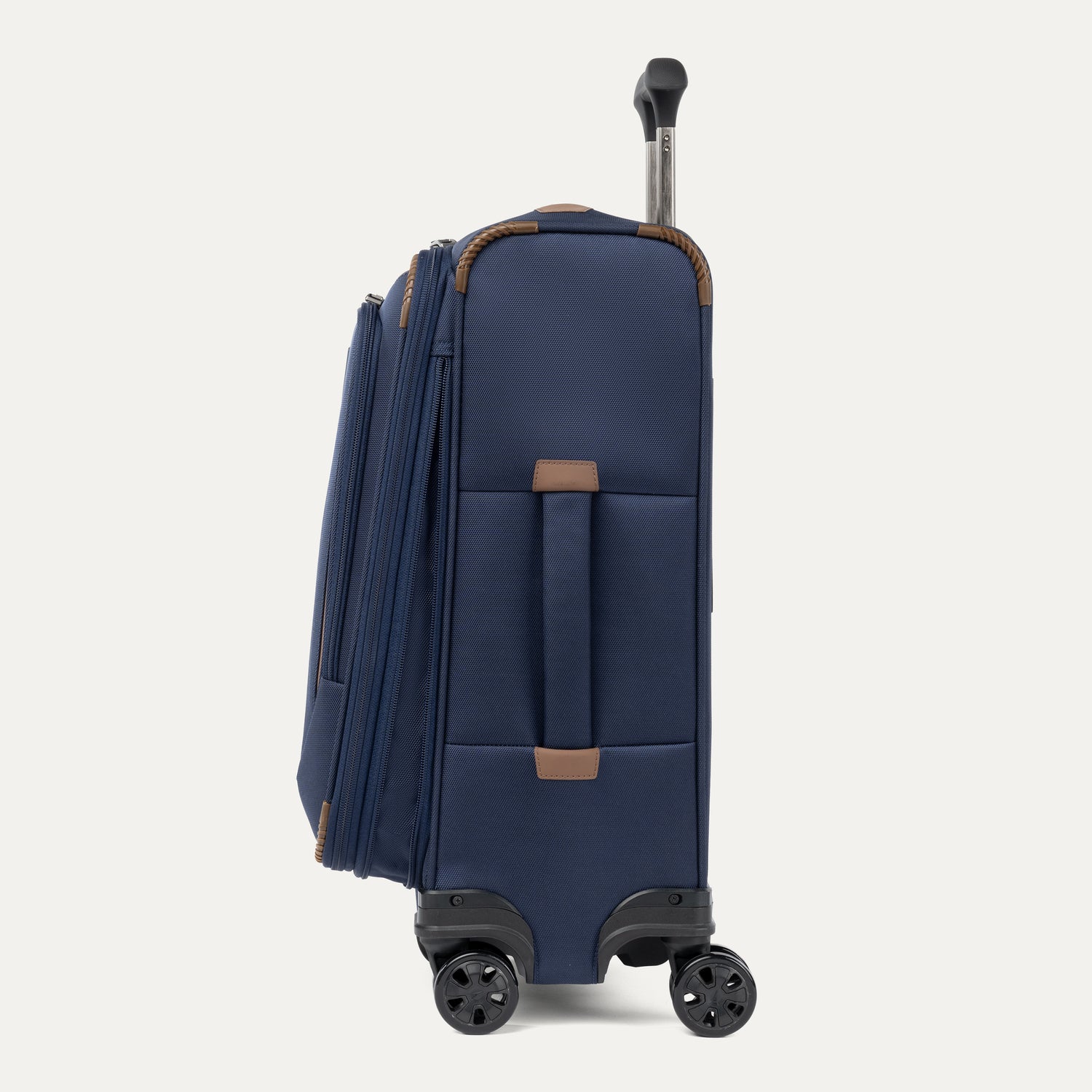 Side view of Travelpro Crew Classic Expandable Spinner in Navy, featuring side carry handle, and smooth-rolling 360° Spinner Wheels.
