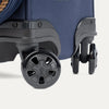 Close-up of the Travelpro Platinum Elite Spinner in Navy, highlighting durable Magnetically Self-Aligning Wheels.
