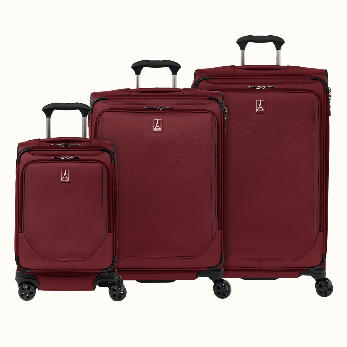 A set of three rosewood red softside spinner suitcases, including a carry-on, medium, and large sizes, aligned in a row with telescopic handles extended.