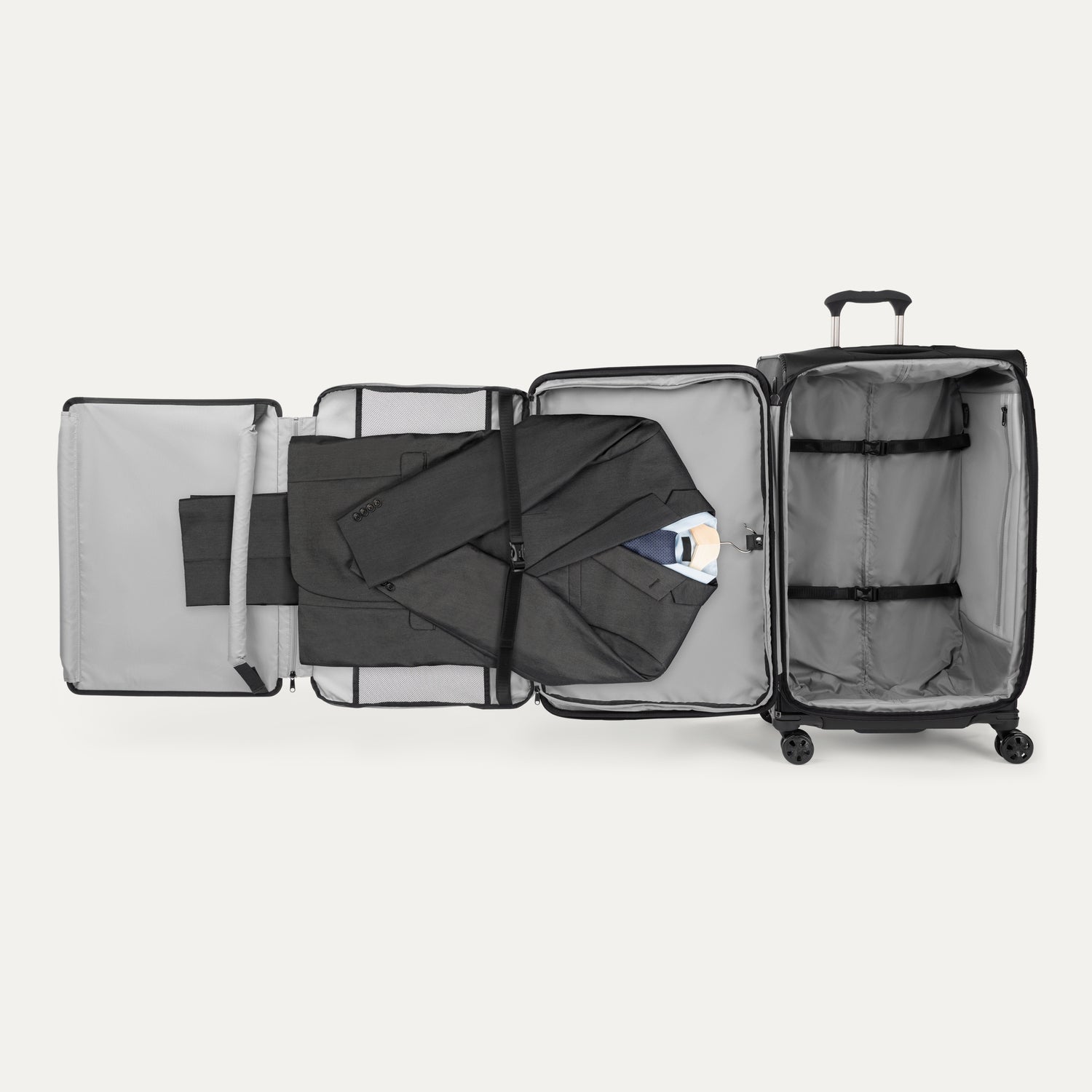 Open suitcase with suit displayed in fold out suiter compartment on white background