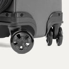 Close-up of a black suitcase with black wheels on a white background