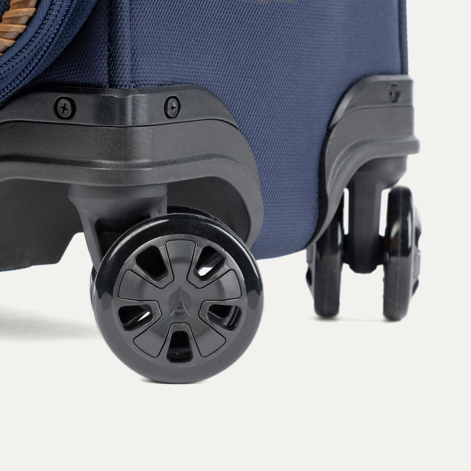 Close-up of a navy blue suitcase with black wheels on a white background
