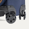 Close-up of a navy blue suitcase with black wheels on a white background