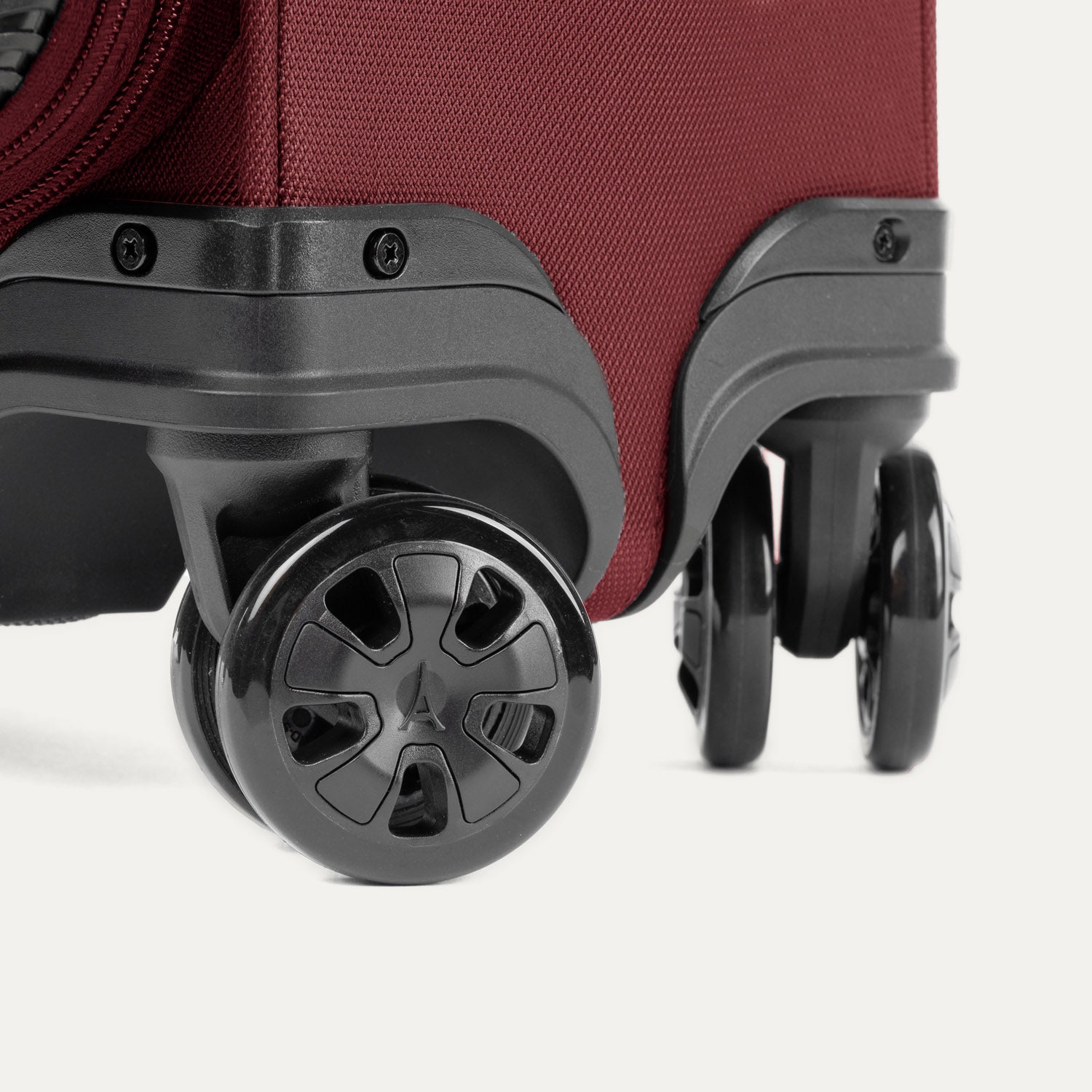 Close-up of the 360° spinner wheels on the Crew™ Classic Spinner in Rosewood Red.
