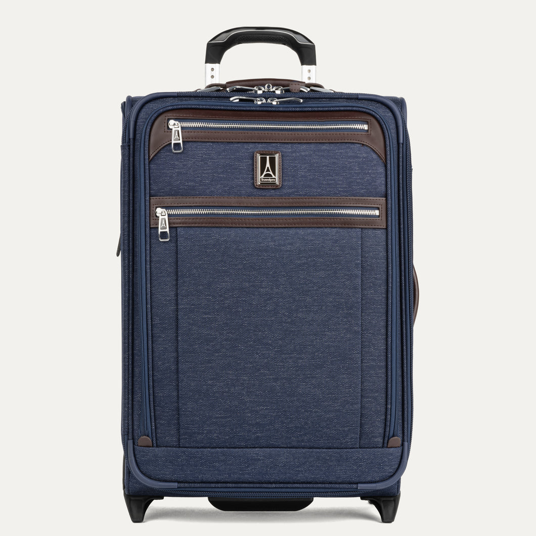 Front view of Travelpro Platinum Elite Carry-On Rollaboard in True Navy, featuring dual front zip pockets, leather accent trim, side carry handle, and telescoping handle.
