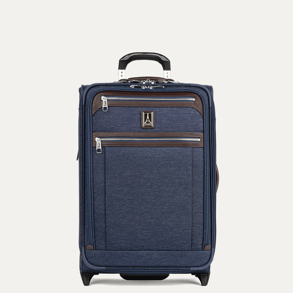 Front view of Travelpro Platinum Elite Carry-On Rollaboard in True Navy, featuring dual front zip pockets, leather accent trim, side carry handle, and telescoping handle.