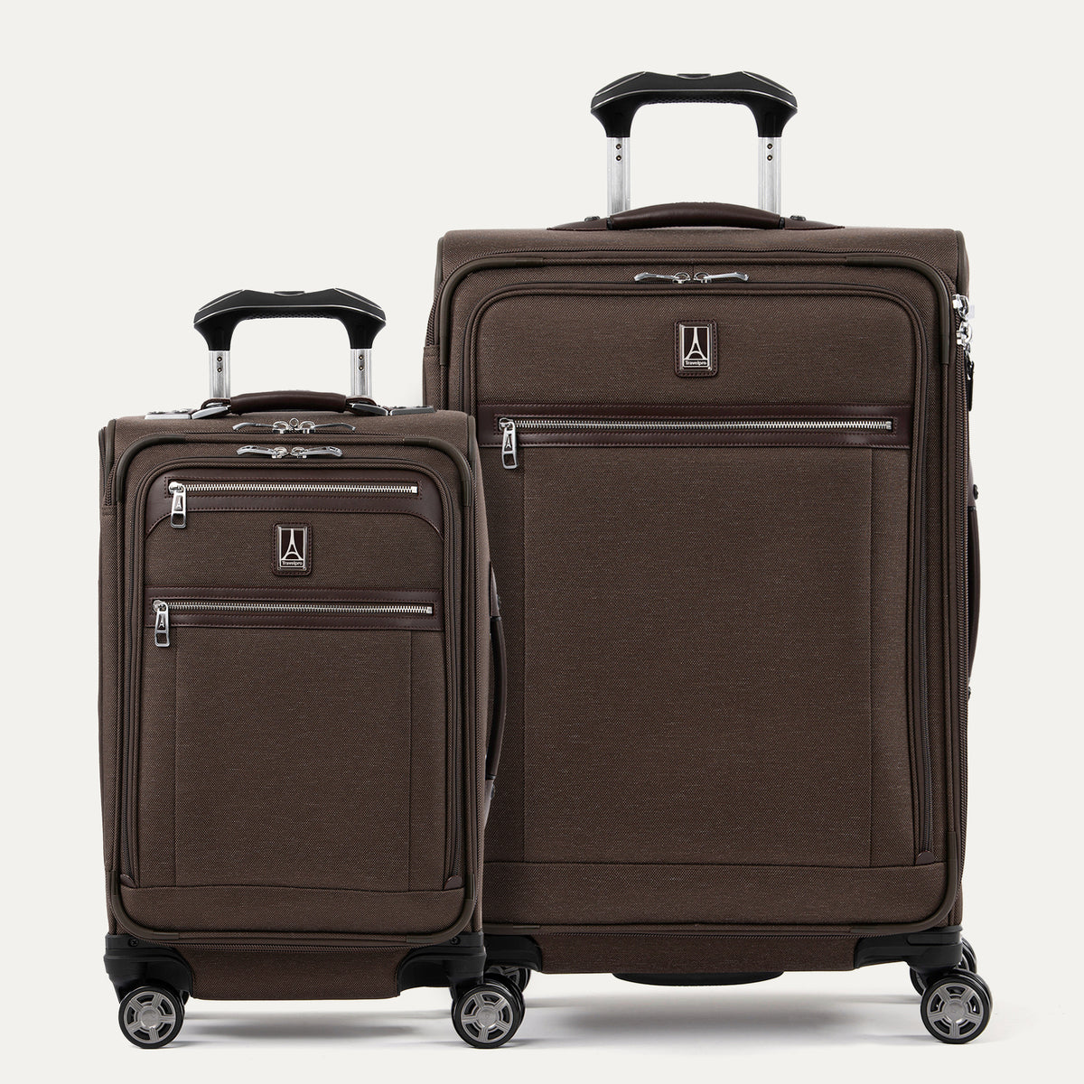 A set of two brown Platinum Elite spinners, one carry-on and one medium check-in size, with chrome zippers and a leather accent on the front pocket.