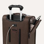Top view of a brown expandable spinner luggage with a USB cable plugged into an integrated USB port, featuring a telescopic handle and chrome zippers.