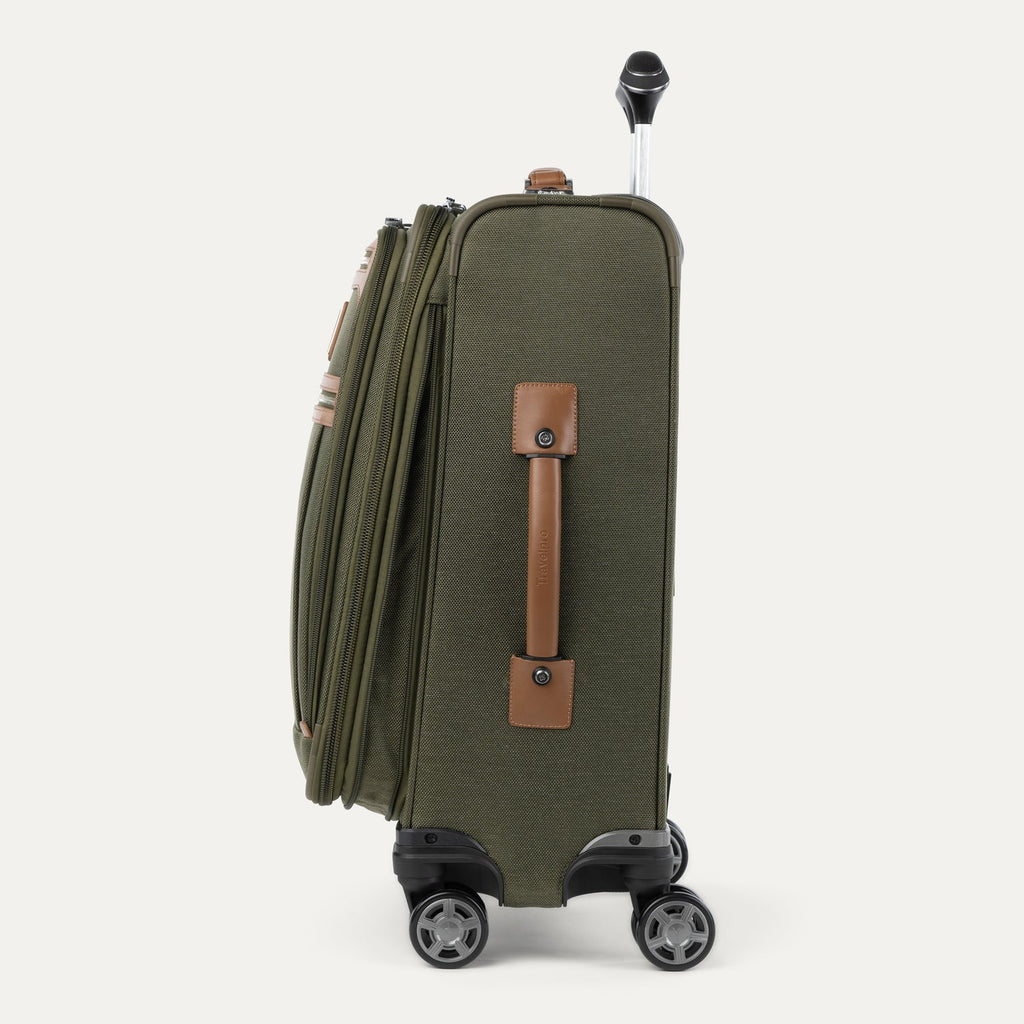 Side view of expanded green suitcase with handles and wheels on a white background