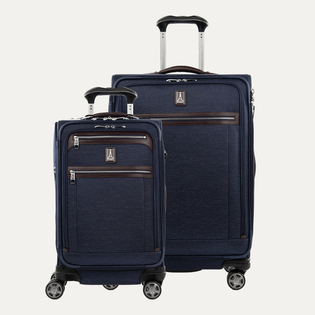 A set of two navy blue Platinum Elite spinners, one carry-on and one medium check-in size, with chrome zippers and leather accents.