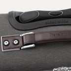 Close-up of a suitcase handle with a brown leather strap 