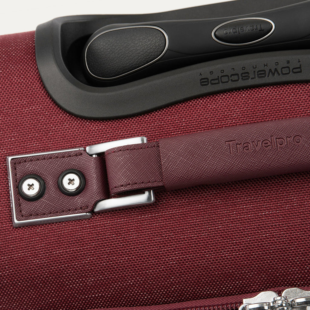 Close-up of a red suitcase handle and lock mechanism.