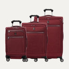 A set of three expandable spinner luggage bags in red color, including a carry-on size and two larger sizes, with chrome zippers and a leather accent on the front pocket.