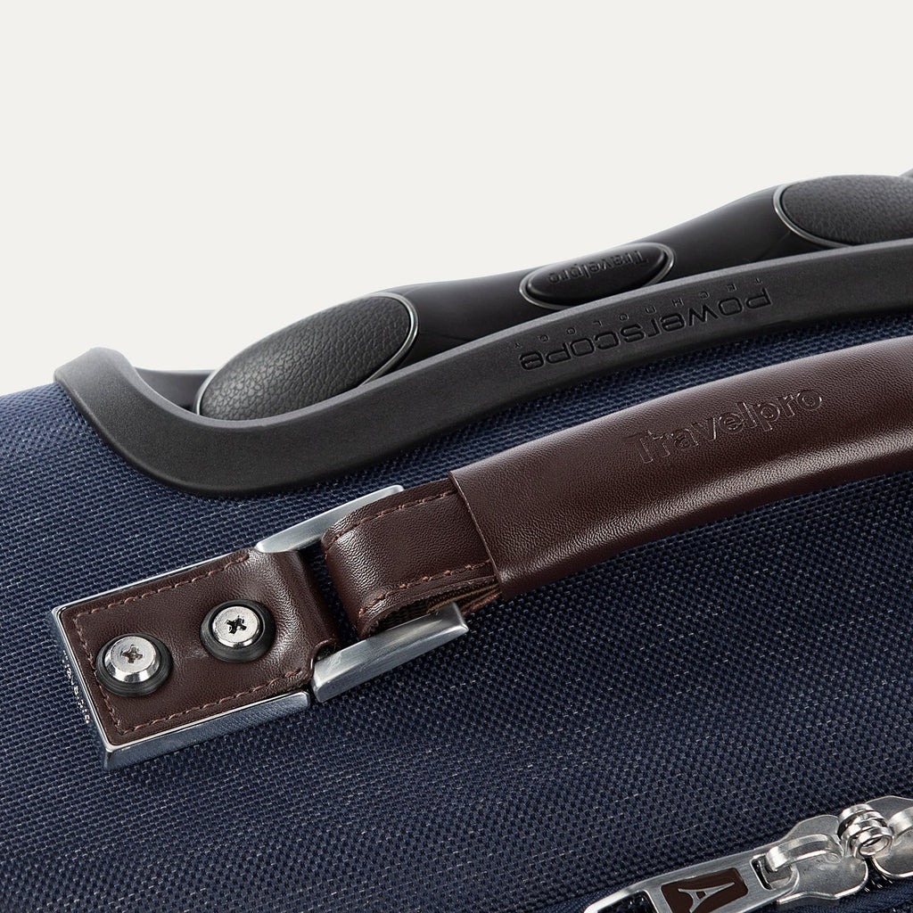 Close-up of a suitcase handle with a brown leather strap 