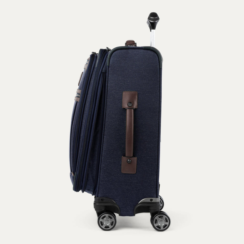 side view  of navy blue suitcase with wheels and handle on a white background