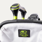 Close-up of the 'Power Bank Pocket' feature on the Platinum Elite Neon Shadow Carry-On in black, highlighting the dedicated zippered pocket with a battery icon and the ergonomic top handle with neon green accents.
