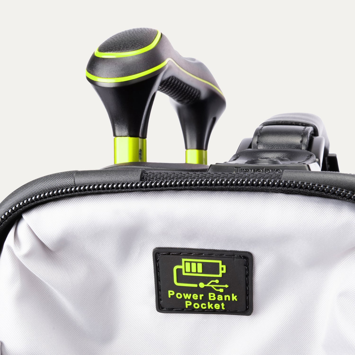 Close-up of the 'Power Bank Pocket' feature on the Platinum Elite Neon Shadow Carry-On in black, highlighting the dedicated zippered pocket with a battery icon and the ergonomic top handle with neon green accents.