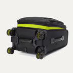 Low-angle view of the Platinum Elite Neon Shadow Carry-On in black, focusing on the durable spinner wheels and the bottom-rear construction, highlighting the sturdy base design and the signature neon green accents on the wheel caps.