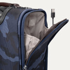  Platinum® Elite Carry-On Spinner in Camouflage showing open side pocket with visible USB cable and labeled power bank pocket inside.
