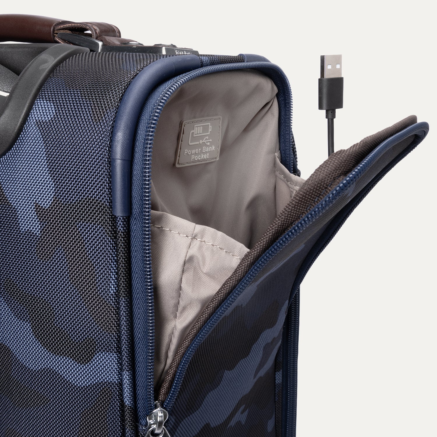  Platinum® Elite Carry-On Spinner in Camouflage showing open side pocket with visible USB cable and labeled power bank pocket inside.

