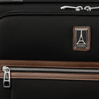Close-up of the Travelpro logo patch, leather-trimmed front pocket, and chrome zipper accents on the Platinum® Elite Medium Check-In Spinner - Limited Edition Colors in Heritage Black.