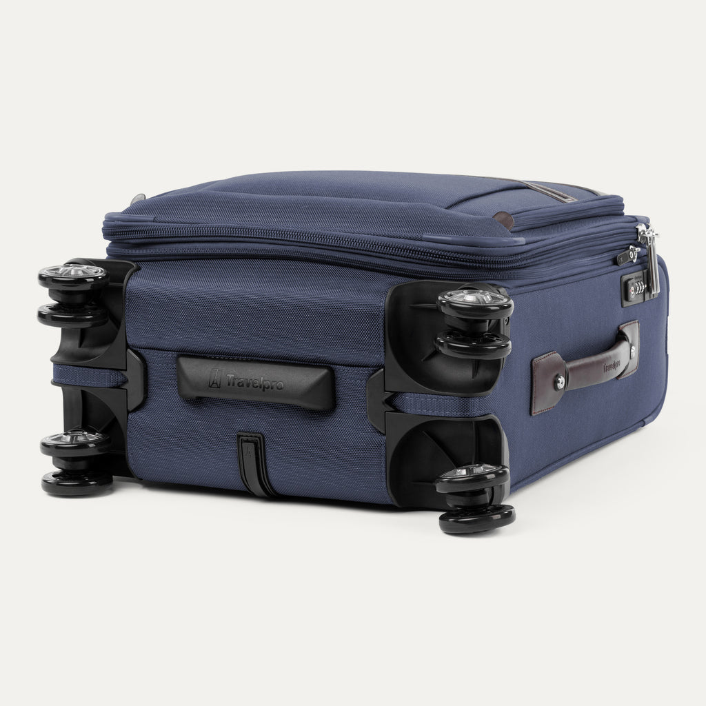 Bottom view of the Travelpro® Platinum® Elite International Carry-On Spinner in True Navy, highlighting its 360° spinner wheels and leather side handle.
