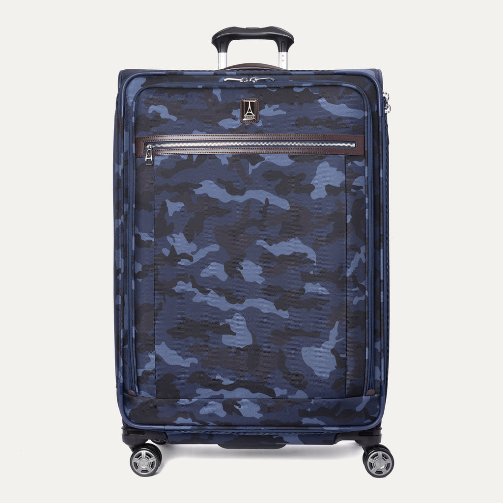 A large check-in spinner suitcase with a camouflaged pattern, featuring leather accents, chrome zippers, and a TSA-compliant lock.