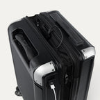 Close-up of a black suitcase with USB cable outlet on a white background.