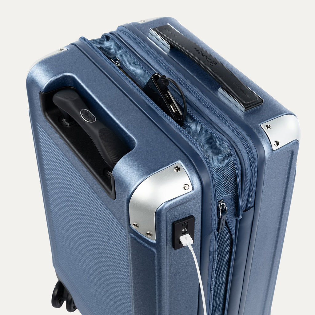 Close-up of a blue suitcase with USB cable outlet on a white background.