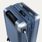 Close-up of a blue suitcase with USB cable outlet on a white background.