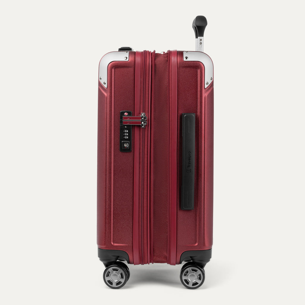 Side view of expanded red suitcase with combination lock on a white background
