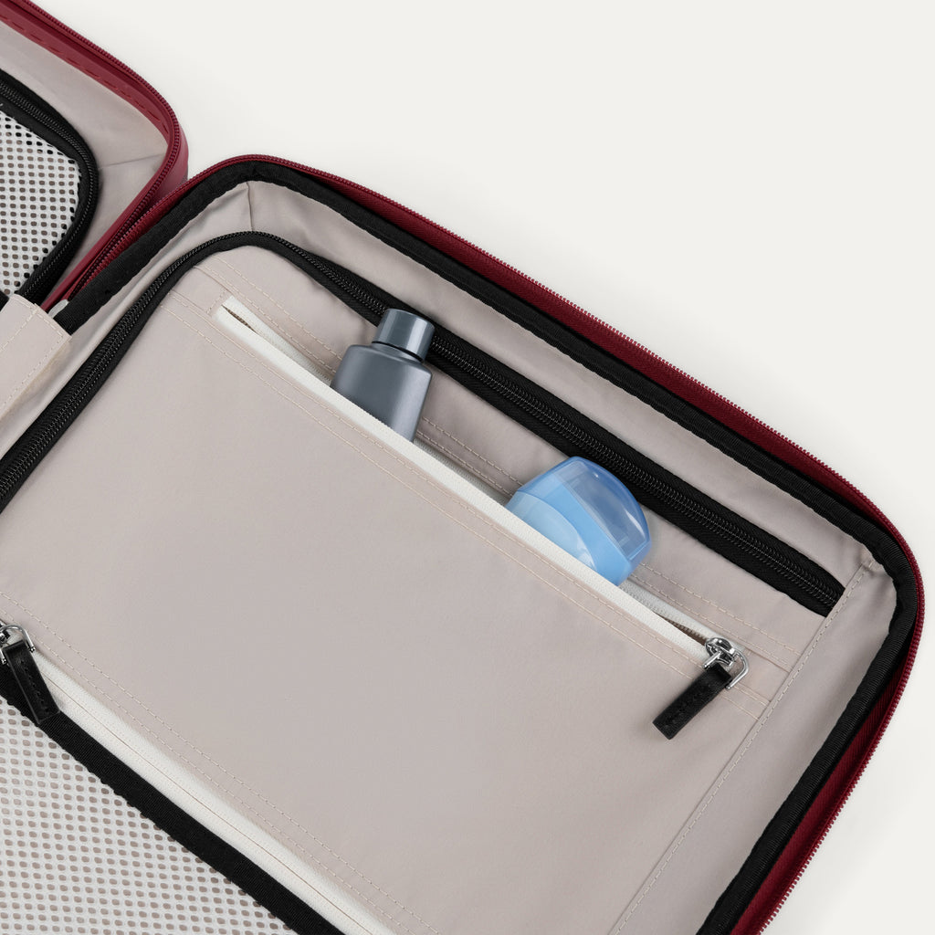 Close-up of a open suitcase interior compartment with toiletries inside.