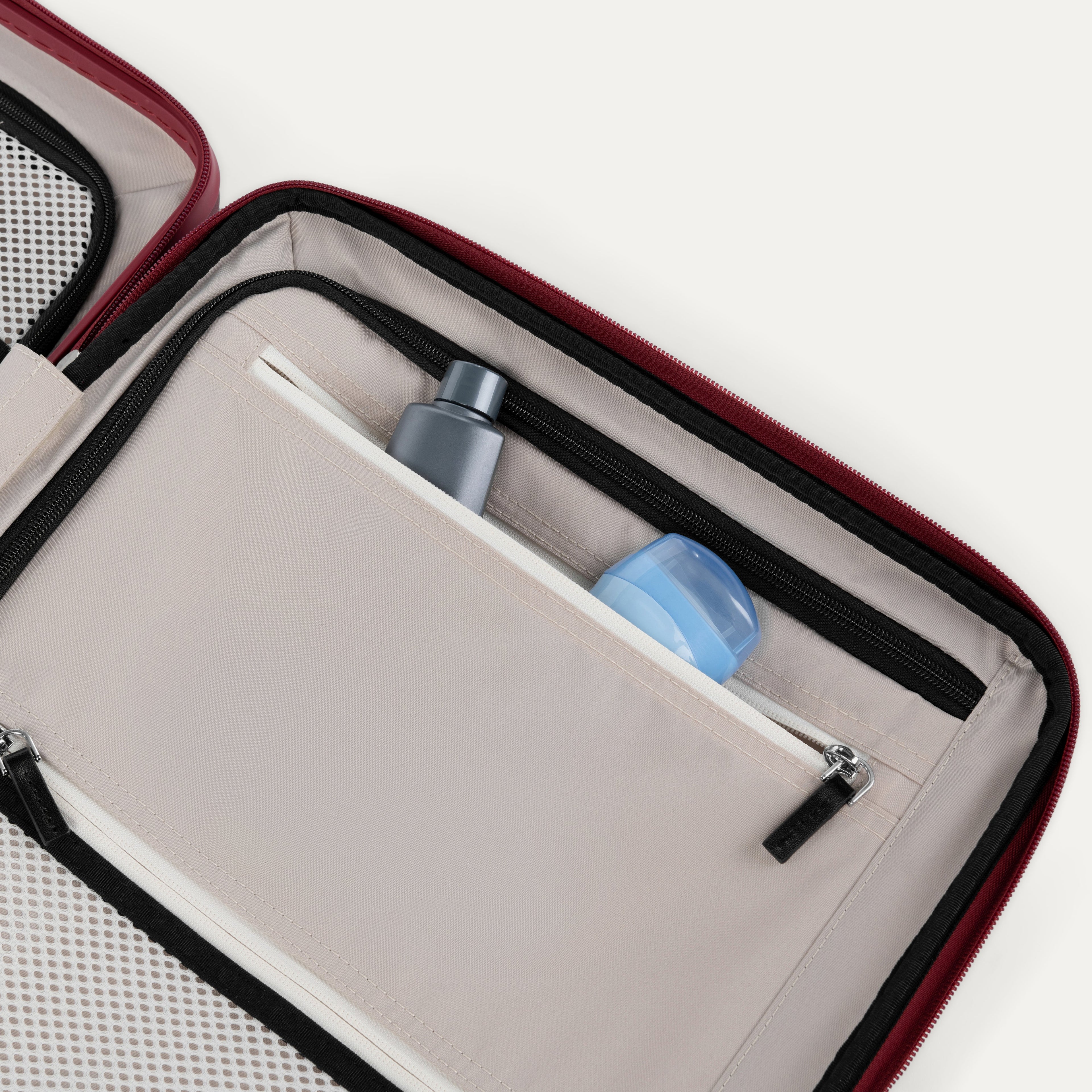 Close-up of a open suitcase interior compartment with toiletries inside.