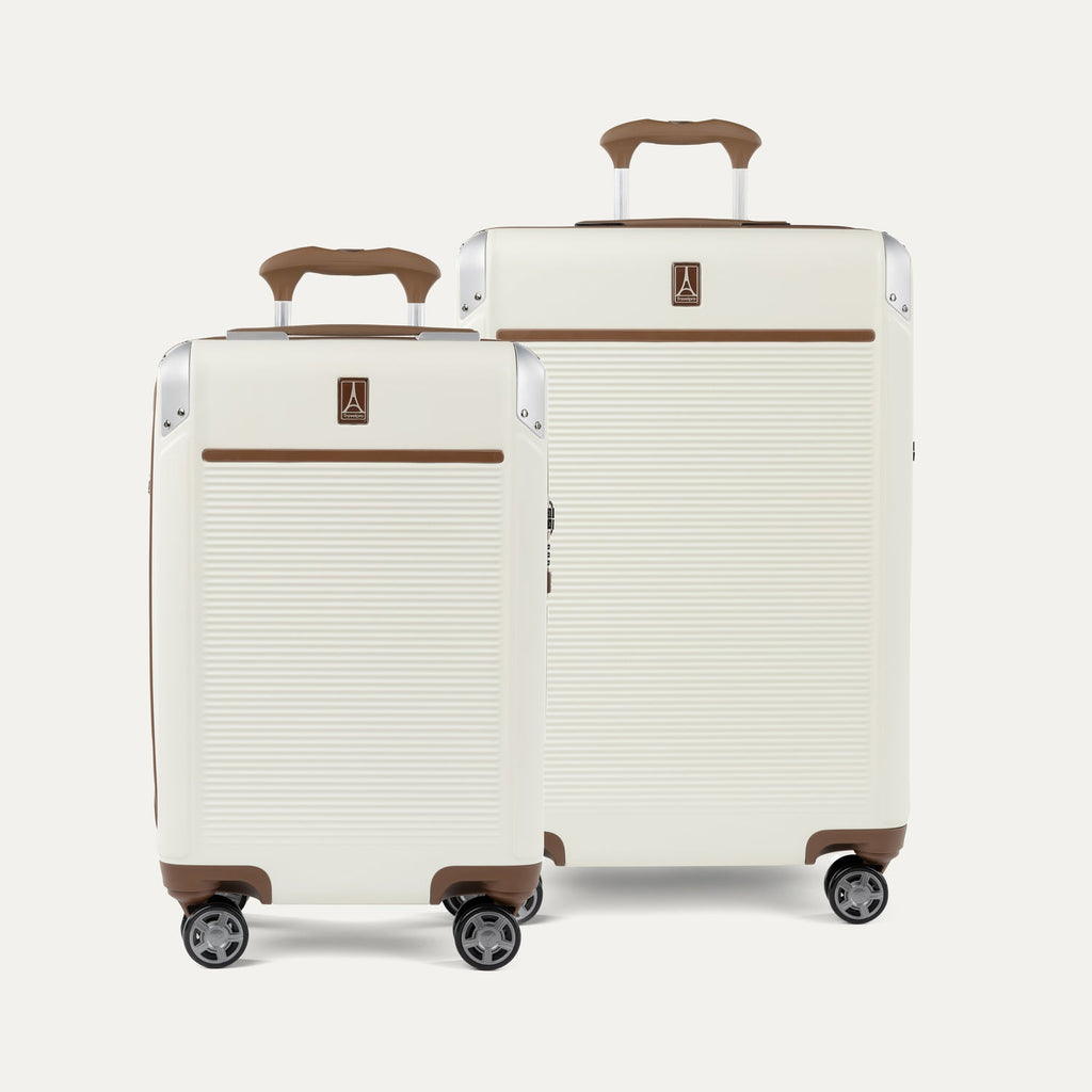 A set of two Platinum Elite hardside spinner suitcases in cream white , including a carry-on and a medium check-in size, featuring brown leather trim and aluminum corner protectors.