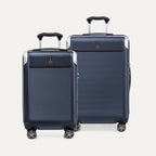 A set of two navy blue hardside spinner suitcases, one carry-on and one medium check-in size on a white background