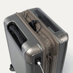 Close-up of a metallic sand  suitcase with a power bank and USB cable.
