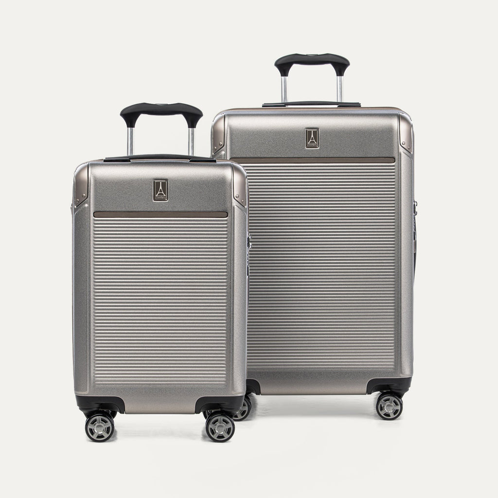 Two metallic sand suitcases with black handles on a plain background