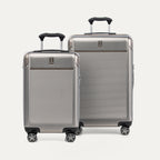 Two metallic sand suitcases with black handles on a plain background