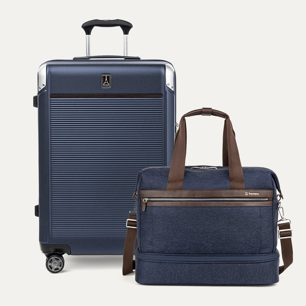 Navy blue suitcase and matching duffel bag with brown straps on a white background