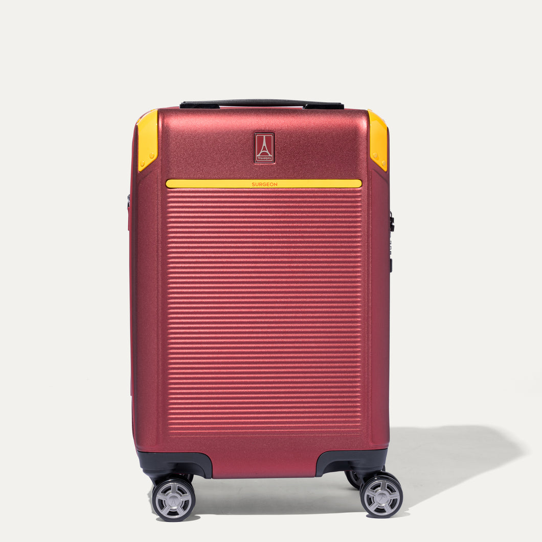 A red and yellow Travelpro x SURGEON hardside carry-on spinner suitcase with  wheels.