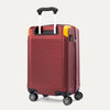 Slanted Rear view of Travelpro x Surgeon Spinner in Daring Red with yellow corner guards, extended PowerScope handle, and textured back panel.
