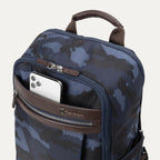 Close-up view of Travelpro Platinum Elite Slim Backpack in Navy Camouflage with phone in QuickSlip front pocket.
