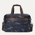  Front view of the Platinum® Elite Soft Duffel in blue camouflage, featuring dual brown handles with a snap closure, a leather-trimmed front zipper pocket, and an adjustable shoulder strap.
