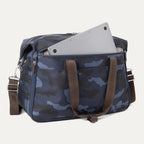 Rear view of Platinum® Elite Soft Duffel in Camouflage with brown handles, featuring a padded exterior pocket holding a laptop.

