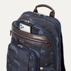 Platinum® Elite Business Backpack in camouflage with a brown leather accent zipper pocket, holding a silver smartphone in the front zippered compartment.