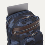 **Alt text:** Platinum® Elite Business Backpack in camouflage, shown with a laptop partially inserted into its padded top compartment.
